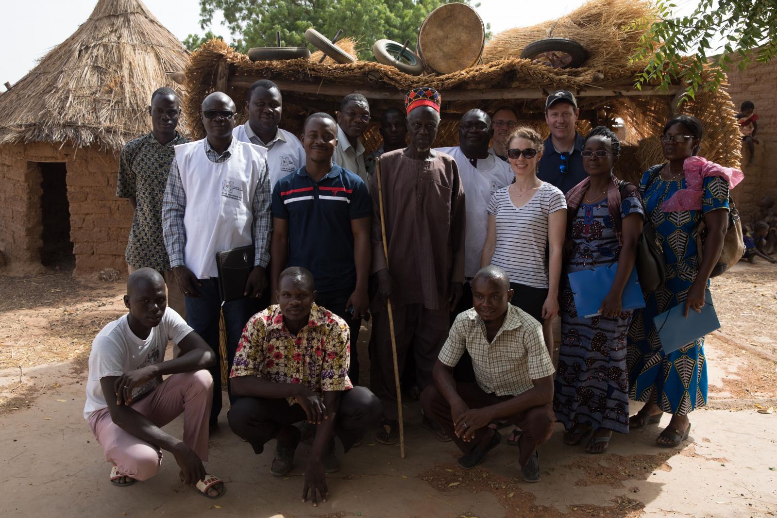 menafrinet team standing in front of a village house