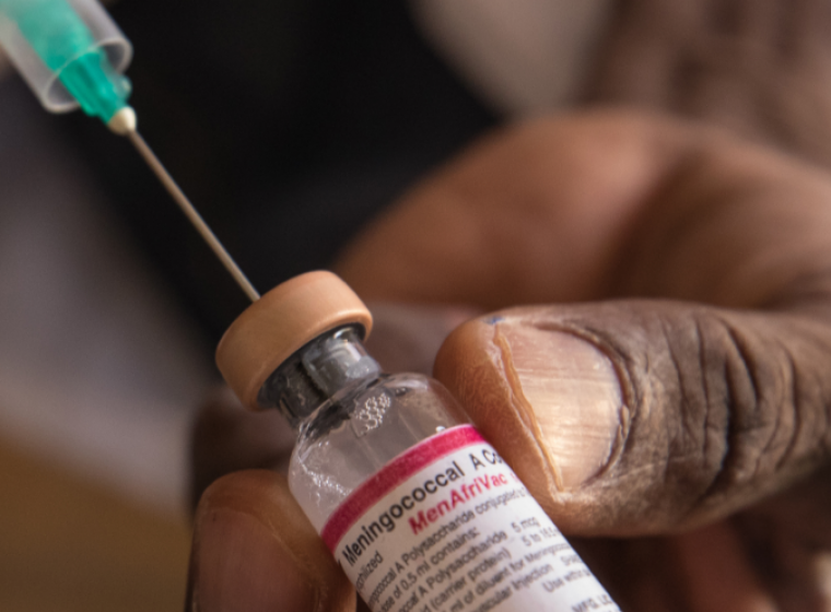 Syringe is inserted into a vial of the MenAfriVac vaccine.